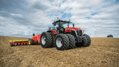 Massey Ferguson 9S Series tractor with dual rear wheels pulling a planter across a harvested field