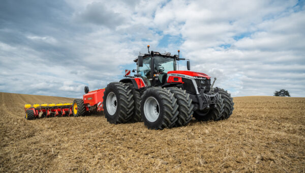 Massey Ferguson 9S Series tractor with dual rear wheels pulling a planter across a harvested field