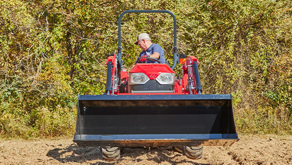 Front view of a Massey Ferguson 1E Series compact tractor, showcasing its powerful design and front loader capability for maximum productivity.