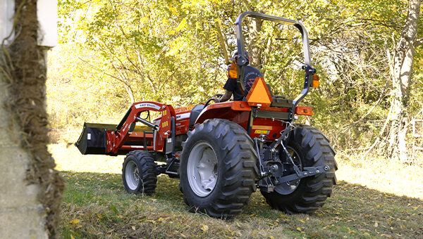 Massey Ferguson 2E Series compact tractor rear view, highlighting robust 3-point hitch and wide, heavy-duty tires for superior traction and stability in rugged terrain.