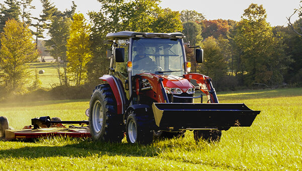 Massey Ferguson 2M Series compact tractor equipped with a front loader and mid-mount mower, ideal for efficient property maintenance and landscaping tasks.