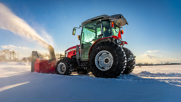 Massey Ferguson 2M Series compact tractor with a rear-mounted snow blower, clearing deep snow with powerful performance in winter conditions.